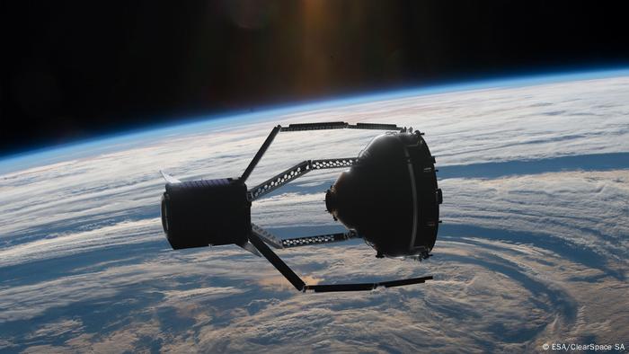 A satellite is seen grabbing another satellite in Earth orbit